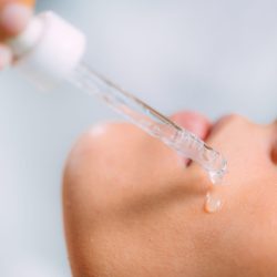 Cosmetician Applying Hyaluronic Acid Serum on Woman’s Face