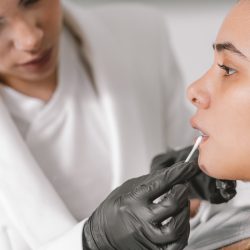 Close-up side view of a client and doctor during a lips augmentation procedure